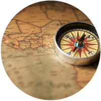 A close-up of a compass resting on an old map, showcasing geographical details and a vintage aesthetic.